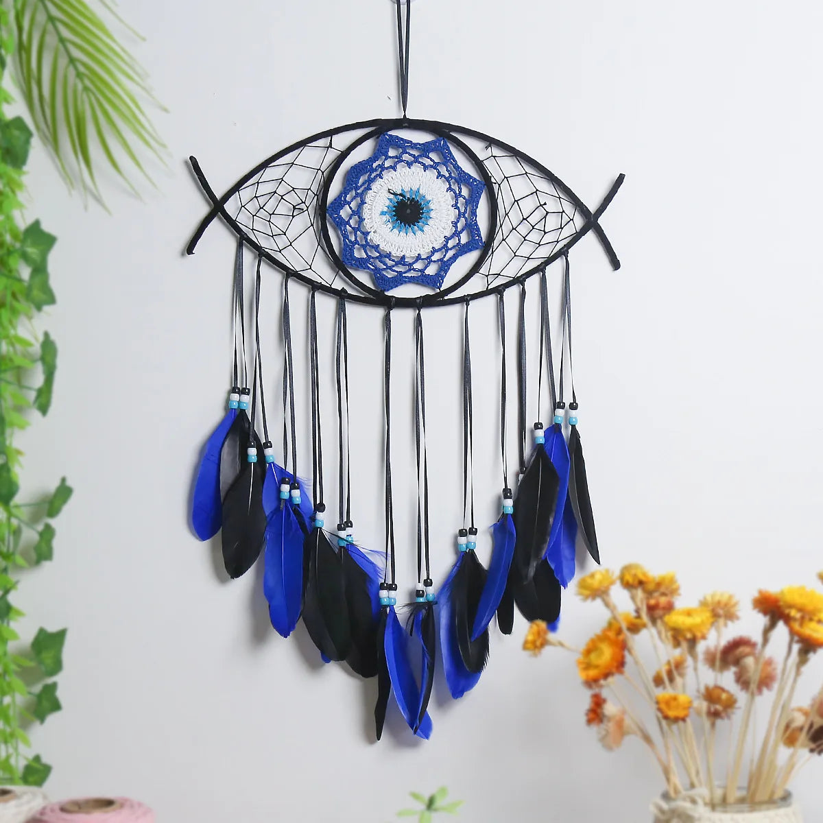 Evil eye dream catcher with blue feathers, product photo
