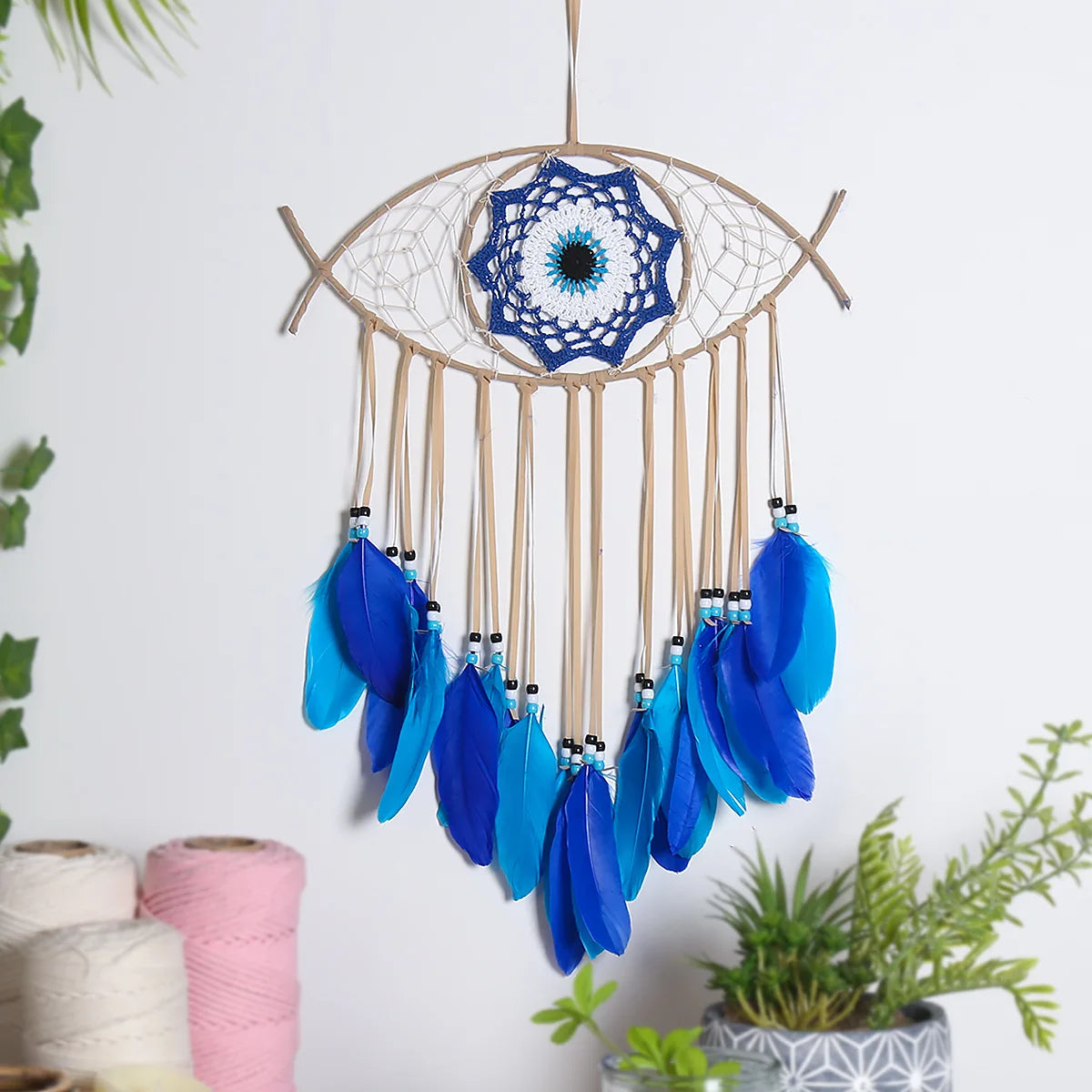 Evil eye dream catcher with blue feathers, product photo