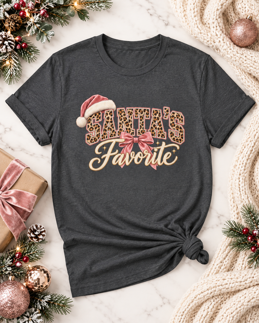Grey Santa's Favorite leopard Christmas tee flat lay with pink holiday decor